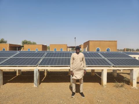 Un homme debout devant des panneaux solaires