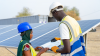 Homme et femme discutant avec des panneaux solaires en arriere plan 